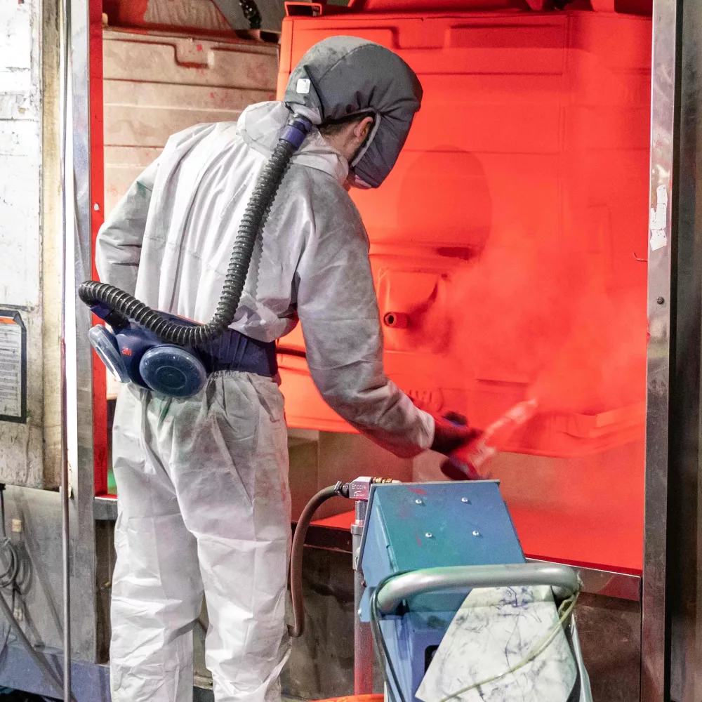 Specialist refurbishing a waste container